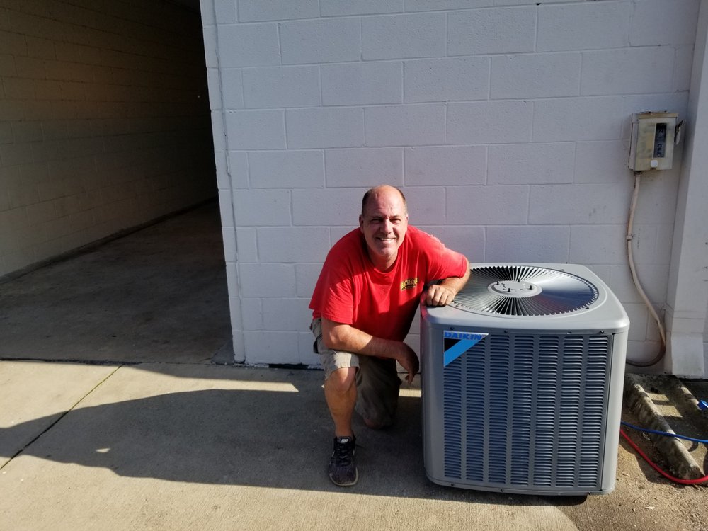Mark Kinney next to a newly installed Daikin HVAC unit